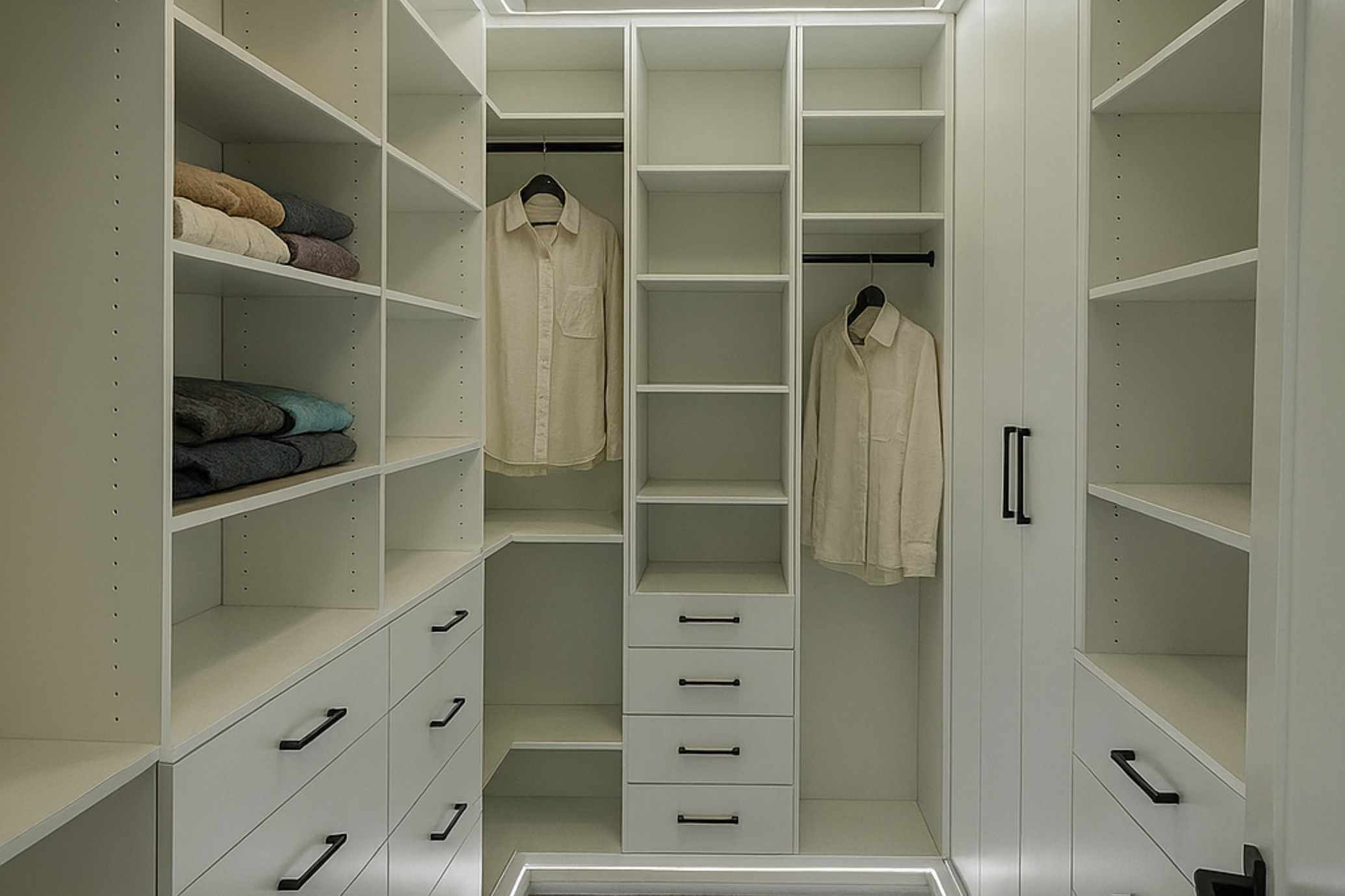 Elegant walk-in closet with glass shelving